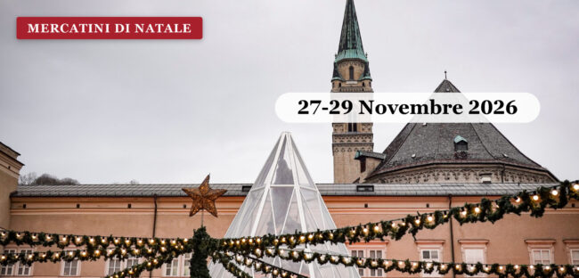 Mercatino di Natale austriaco illuminato sotto un campanile