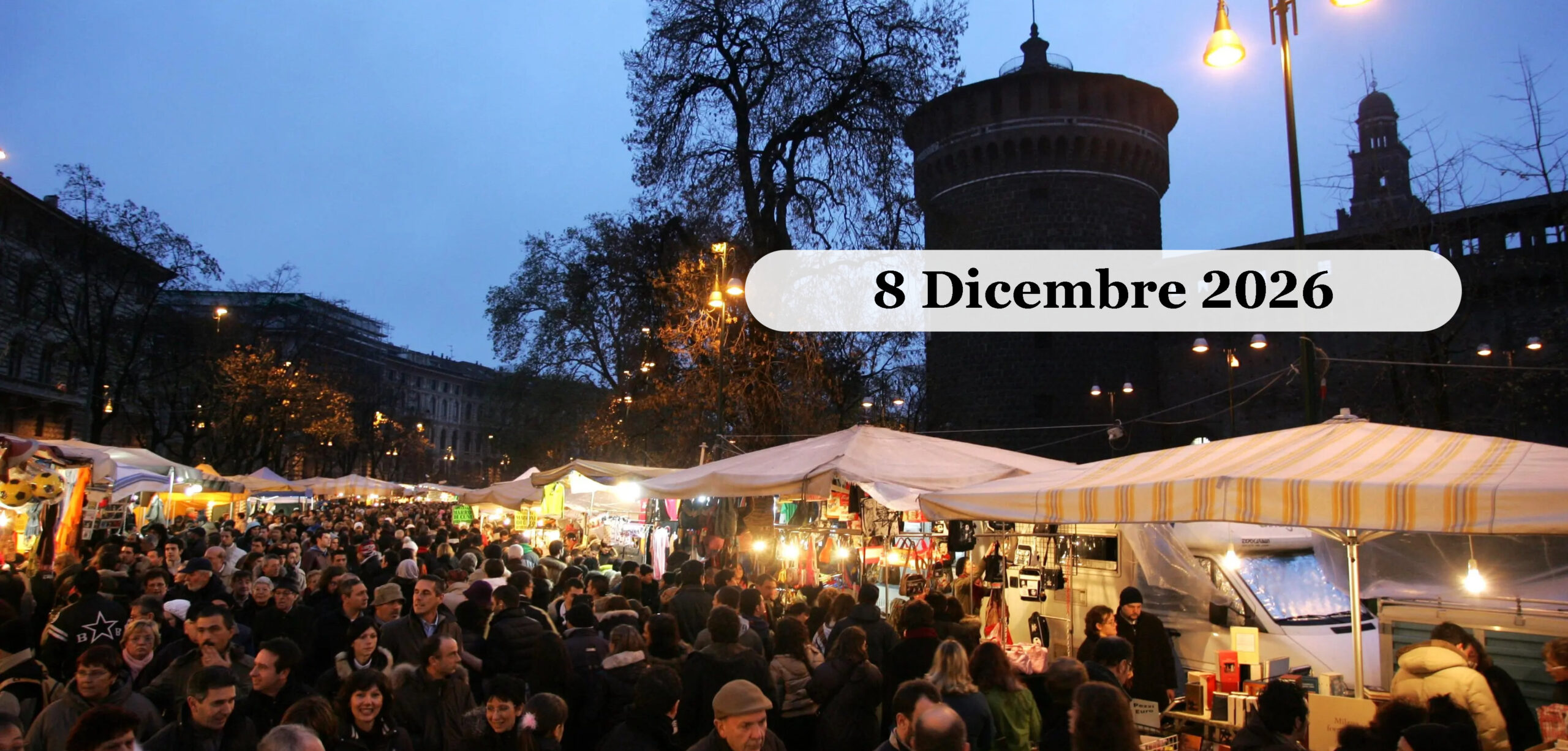 Fiera Oh Bej Oh Bej a Milano Dicembre 2026 Le bancarelle serali della fiera Oh Bej Oh Bej a Milano, con la folla e il Castello Sforzesco sullo sfondo